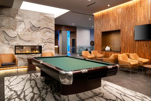 a pool table in a room with a fireplace at Hyatt House LAX Century Blvs in Los Angeles