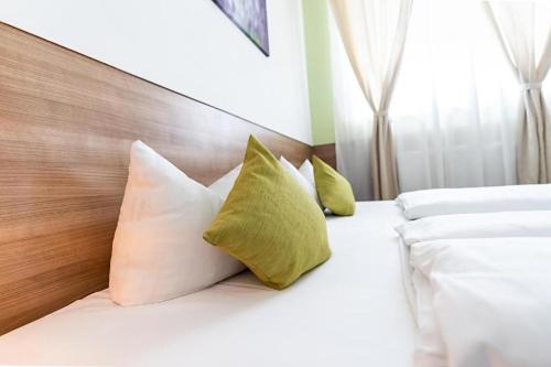 a bedroom with a bed with white sheets and pillows at Apartimo Altdorf in Landshut
