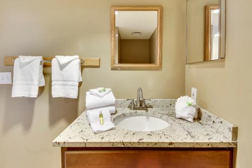 Un baño con lavabo, espejo y toallas. en Phoenix 6 Unit 615, en Orange Beach