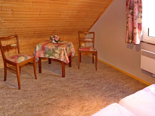 a dining room with two chairs and a table with a tablecloth at Ferienhaus nahe Ostsee und Wald in Neubukow