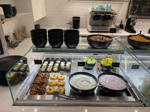 a counter topped with lots of different types of pastries at Swiss-Belsuites Victoria Park Auckland in Auckland