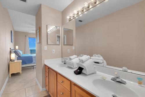 Un baño con lavabo y un espejo grande. en Phoenix 7 Unit 1110, en Orange Beach