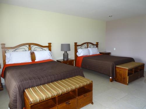 two beds in a hotel room with two beds at HOTEL XIADANI Restaurante, Temazcal & Spa in Tlaxcala de Xicohténcatl