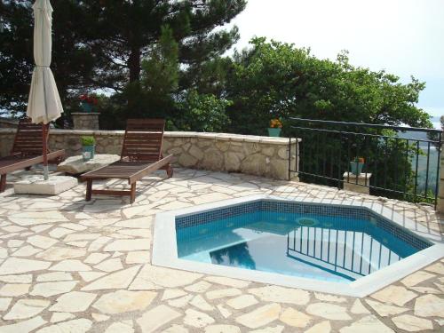 una piscina en un patio con mesa y sillas en Merlot Village Rental Apartments, en Kariá