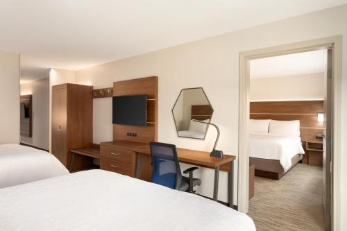 a hotel room with two beds and a desk at Holiday Inn Express & Suites Searcy by IHG in Searcy