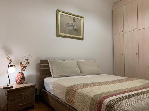 1 dormitorio con 1 cama y una foto en la pared en 2 Bedrooms Apartment Center of Athens 4 min Subway, en Atenas