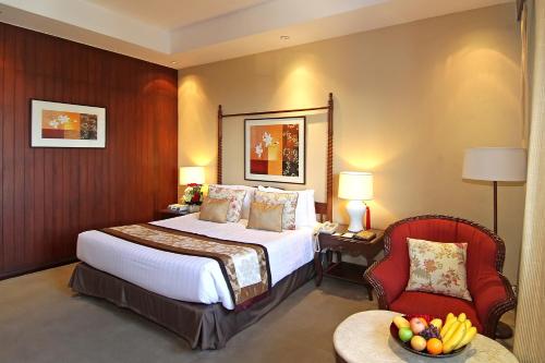 a hotel room with a bed and a chair at The Manila Hotel in Manila