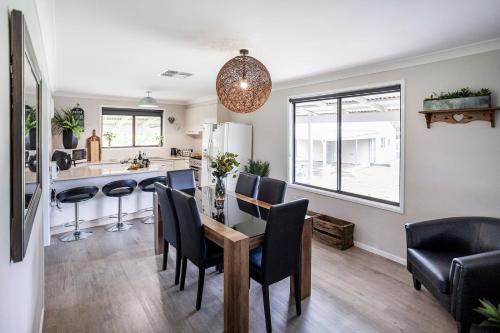 a kitchen and dining room with a table and chairs at EdenValley Private Manicured Gardens with Fire Pit in Parkes