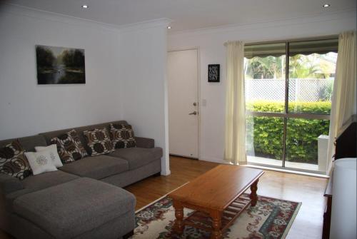a living room with a couch and a coffee table at Jarrah by Kingscliff Accommodation in Kingscliff