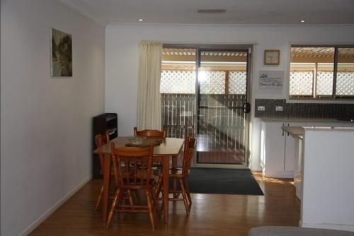 a kitchen and dining room with a table and chairs at Jarrah by Kingscliff Accommodation in Kingscliff
