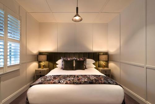 a bedroom with a large bed with two lamps at Alexander Cottage Daylesford in Daylesford