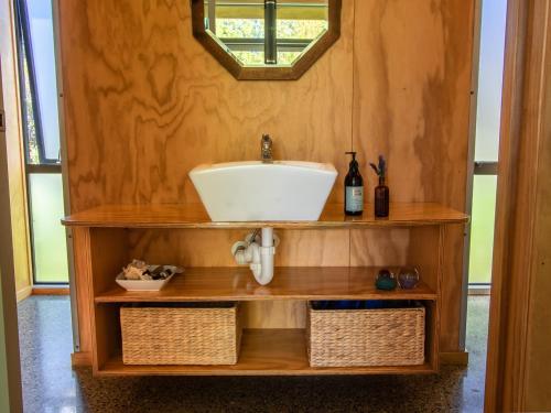 baño con lavabo en una estantería de madera en Marahau Magic - Marahau Bach, en Marahau