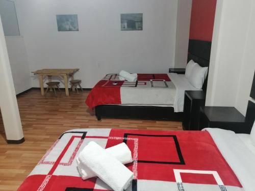 two beds with red and white blankets in a room at Hotel Boutique Otomi cerca de Tolantongo in Cardonal