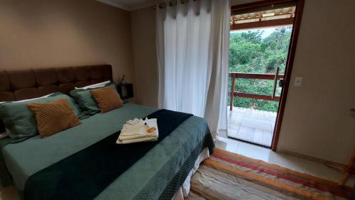 1 dormitorio con 1 cama y ventana grande en Recanto dos Ipês Pousada, en Divisa