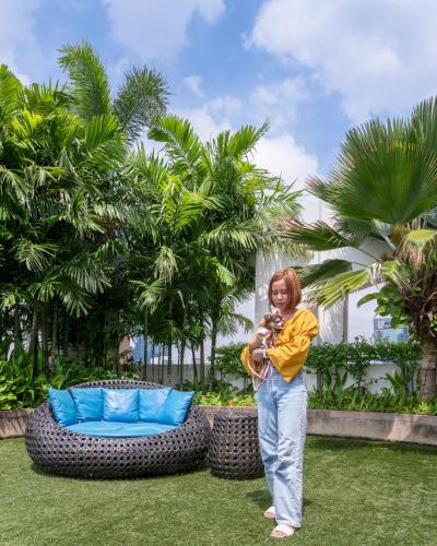a woman standing in the grass near a couch at Grand Asoke Suites Boutique Residence in Bangkok