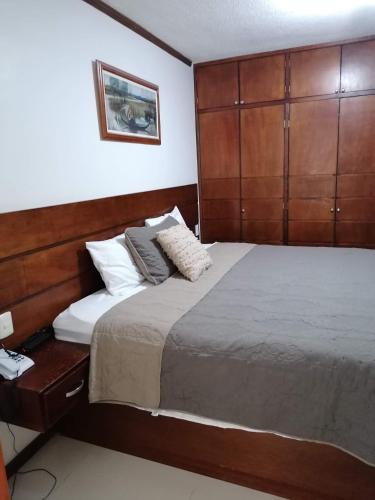 a bedroom with a large bed with a wooden headboard at La Aurora Hotel Like Home in Huamantla