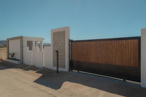 a house with a wooden fence and a gate at Collins Village Hotel Boutique in El Porvenir