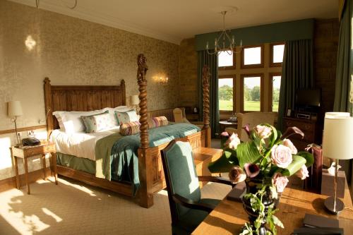 a bedroom with a bed and a table with a chair at South Lodge in Lower Beeding