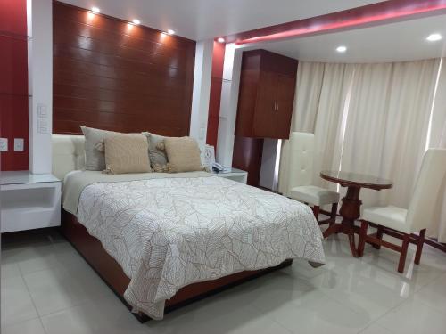 um quarto com uma cama, uma mesa e uma cadeira em La Aurora Hotel Like Home em Huamantla