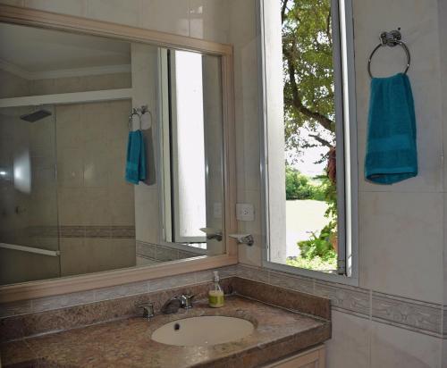 a bathroom with a sink and a mirror and a window at Cristales, Condominio Lagos del Peñon in Girardot