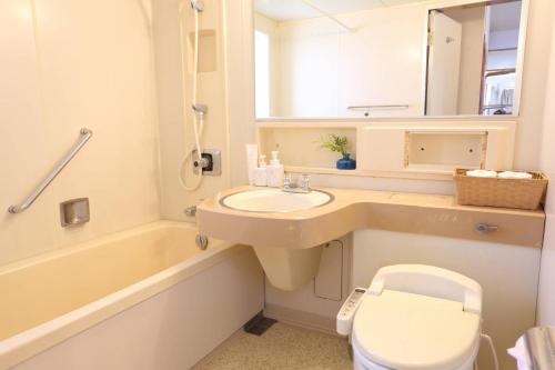 a bathroom with a sink and a tub and a toilet at YURURI private cottage in Tonosho