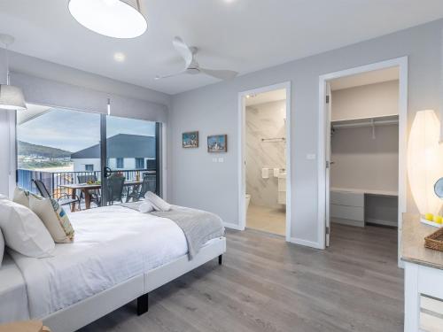 a bedroom with a bed and a balcony at Fingal Bay Seabreeze Unit 2 16 Tuna Crescent in Fingal Bay