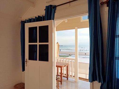 an open door to a balcony with a view of the beach at Cocos Beach Resort in Palolem