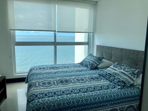 1 dormitorio con cama y ventana grande en Eliptic Cartagena-Oceano, en Cartagena de Indias