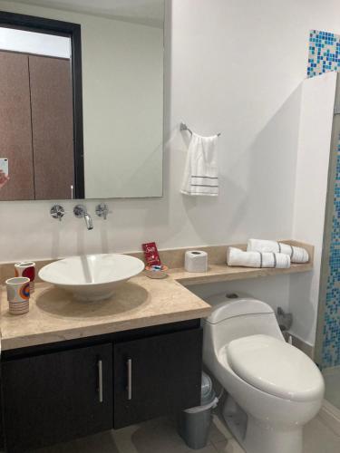 a bathroom with a sink and a toilet and a mirror at Eliptic Cartagena-Oceano in Cartagena de Indias