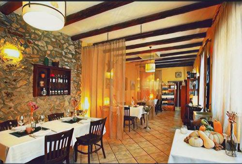 un restaurante con mesas y sillas y una pared de piedra en VÍA NATURA hotel rural gastronómico en Cabanes