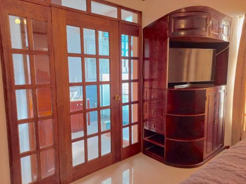 a room with a bed and a tv and glass doors at La Aurora Hotel Like Home in Huamantla