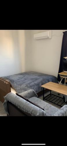 a bedroom with a bed and a wooden table at コンドミニアムホテル　Stay inn Blue room302 in Hukue