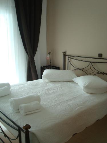 a bedroom with a bed with two towels on it at Merlot Village Rental Apartments in Kariá