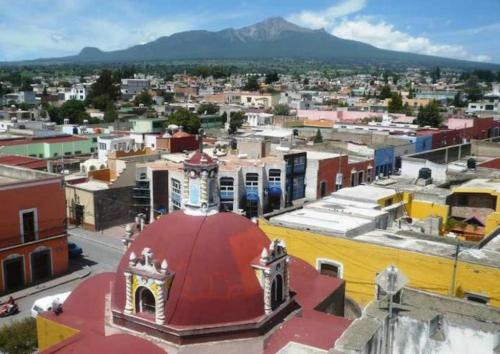 a view of a city with a red roof at La Aurora Hotel Like Home in Huamantla