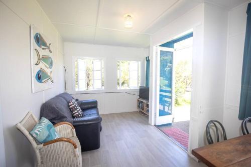 a living room with a couch and a table at Cabana - Original Straddie Beach Shack in Point Lookout