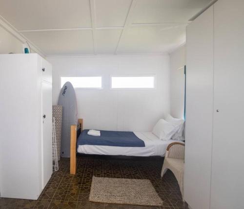 a small bedroom with a bed in a room at Cabana - Original Straddie Beach Shack in Point Lookout