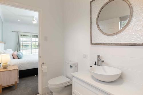 Redims Hill Cottage في نولكابا: حمام أبيض مع حوض ومرآة