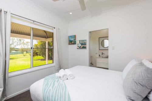Redims Hill Cottage في نولكابا: غرفة نوم بيضاء بها سرير ونافذة