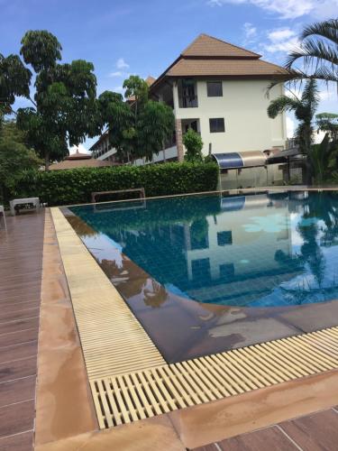 a swimming pool in front of a house at phuriburi resort in Pattaya Central