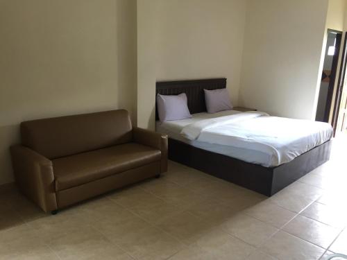 a bedroom with a bed and a chair at phuriburi resort in Pattaya Central