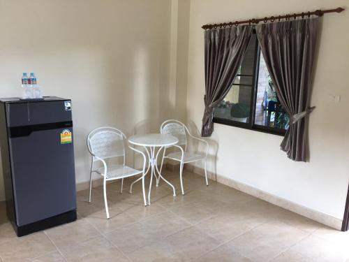 a dining room with a table and chairs and a window at phuriburi resort in Pattaya Central