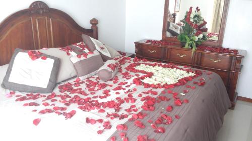 a bed with red and white flowers on it at La Aurora Hotel Like Home in Huamantla