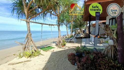 a shop on the beach with palm trees and the ocean at Beach Home Lanta in Ko Lanta