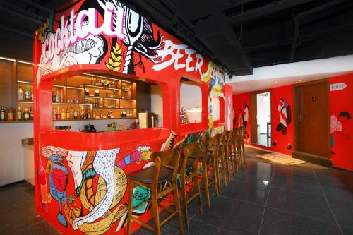 a restaurant with a red wall with chairs at 吃山文化青年旅店 in Chongqing