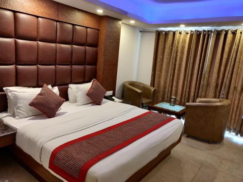 a bedroom with a large bed with a large headboard at Hotel Hamers International in Mussoorie