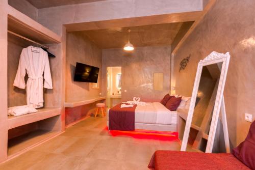 a small bedroom with a bed and a mirror at The Muses of Santorini Private Jacuzzi Suites in Vóthon
