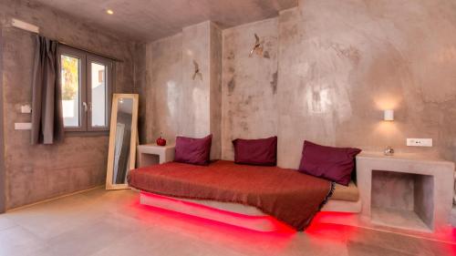 a bedroom with a bed with a red blanket at The Muses of Santorini Private Jacuzzi Suites in Vóthon
