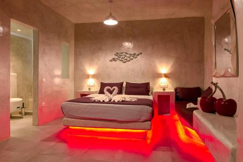 a bedroom with a large bed with red lighting at The Muses of Santorini Private Jacuzzi Suites in Vóthon