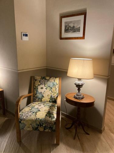 a chair sitting next to a table with a lamp at La Corte Nascosta Volpedo in Volpedo