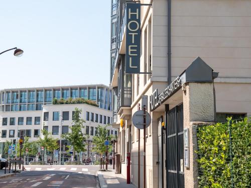a building with a sign on the side of a street at Hôtel Versailles Chantiers in Versailles